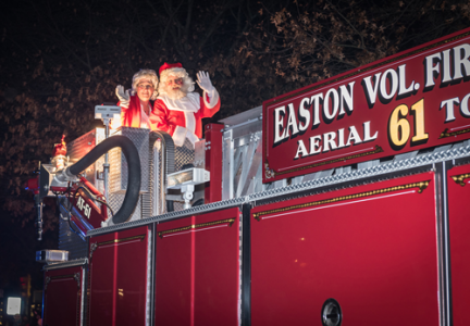 Santa and Mrs. Claus waiving hello from a firetruck in downtown Easton, MD